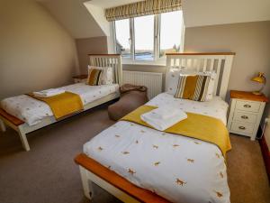 two twin beds in a room with a window at Manor Wood in Coddington