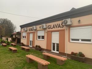 un gruppo di panchine di fronte a un edificio di Sobe Glavaš a Garešnica