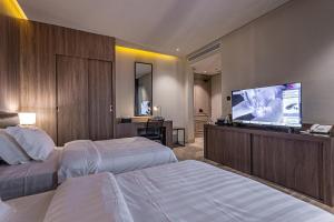 a hotel room with two beds and a flat screen tv at Land walk Hotel in Riyadh