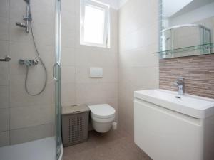 a bathroom with a toilet and a sink and a shower at Apartments Happy Holiday in Rogoznica