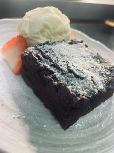 a piece of chocolate cake with ice cream on a plate at George & Dragon Hotel in Buckinghamshire