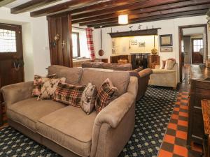 a living room with couches and a living room with a fireplace at Cymryd Uchaf in Conwy