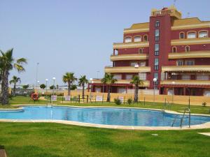 a building with a swimming pool in front of a building at Apartamento Pelicanos Golf & Beach - spacious and modern with terrace and private pool in Roquetas de Mar