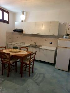 a kitchen with a table and chairs and a refrigerator at La casa tra il verde e il blu in Lipari