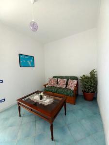uma sala de estar com um sofá e uma mesa de centro em La casa tra il verde e il blu em Lipari