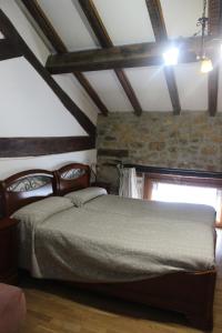 ein Schlafzimmer mit einem Bett und einer Steinmauer in der Unterkunft Errotazar apartamento M in Alsasua