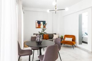 a living room with a couch and a table and chairs at A bright Nest in the heart of Plaka in Athens