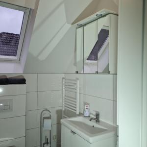 a white bathroom with a sink and a window at Willingen, zeit für Dich in Frankenau +15 photos