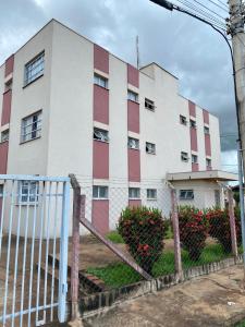 ein weißes und rotes Gebäude mit einem Zaun davor in der Unterkunft Apartamento em Olimpia in Olímpia