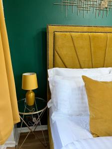 uma cama com um candeeiro amarelo e uma parede verde em Spacious 1 bedroom apartment in the best location in Manchester City Centre em Manchester