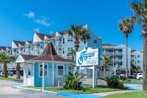 a sign in front of a large building at Charming Beachside Condo Lovely Pool Hot Tubs and Boardwalk in Galveston