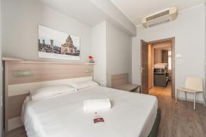 Best Quality Hotel Gran Mogol في تورينو: غرفة نوم مع سرير أبيض كبير في غرفة