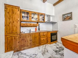 una cocina con armarios de madera y fregadero en Château du Châtelard | Unique Apartment, en Montreux