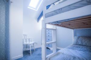 1 dormitorio con litera y escritorio en The Penthouse At The Mews - 2 Bedroom Apartment - Tenby en Tenby
