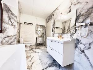 a bathroom with marble walls and a sink and a toilet at Montreux Castle | Charming Lake View Studio in Montreux