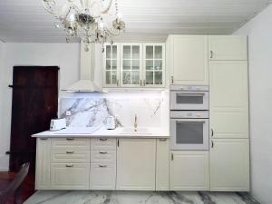 una cocina con armarios blancos y una lámpara de araña en Montreux Castle | Charming Lake View Studio, en Montreux