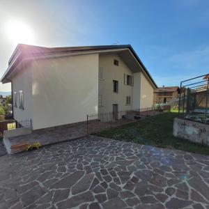 a house with a stone patio in front of it at Attic House Mountain Lake Iseo Hospitality in Bossico