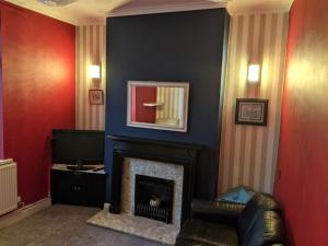 a living room with a fireplace and a mirror at Penarth Town Terrace, close to cafes, beaches, Cardiff in Cardiff