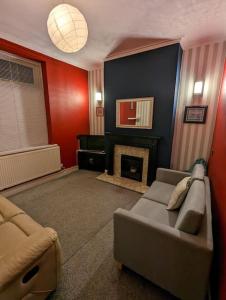 a living room with a couch and a fireplace at Penarth Town Terrace, close to cafes, beaches, Cardiff in Cardiff