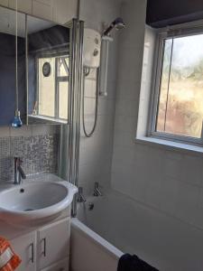 a white bathroom with a sink and a shower at Penarth Town Terrace, close to cafes, beaches, Cardiff in Cardiff