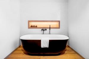 达沃斯ALPINE INN Davos的浴室里的浴缸，墙壁是白色的