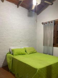 a bedroom with a green bed with a window at Mis Soles in Santa Ana