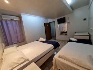 塔瓜汀加Hotel Supreme - Pistão Sul - Próximo ao Taguatinga Shopping的一间医院间,配有两张床和镜子 更多8张照片