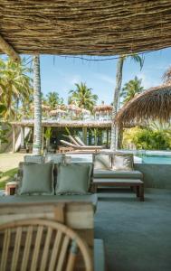 een patio met banken en palmbomen en een resort bij Zai Patacho in Pôrto de Pedras