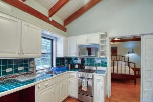 uma cozinha com armários brancos e um forno com placa de fogão em Condo #27 @ Beachside Villas em Dangriga