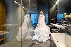 a room with two wedding dresses on display in a bathroom at Nomad Design & Lifestyle Hotel in Basel