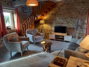 Kervig House Ty Laouen في بيمبول: غرفة معيشة مع أريكة وكراسي وتلفزيون