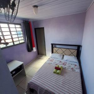 um quarto com uma cama com paredes roxas em Hospedaria Oliveira em São Tomé das Letras