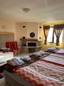 a room with two beds and a fireplace in it at Къща за гости Становец in Stanovets