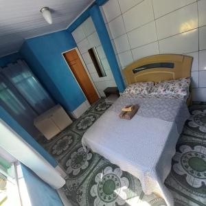 um pequeno quarto com uma cama e uma cabeceira em madeira em Hospedaria Oliveira em São Tomé das Letras