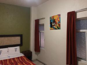 a bedroom with a bed and a painting on the wall at Hotel Vigo in Guadalajara