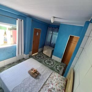 modelo de dormitorio con cama y paredes azules en Hospedaria Oliveira, en São Thomé das Letras