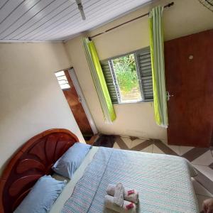 un dormitorio con una cama con dos animales de peluche en Hospedaria Oliveira, en São Thomé das Letras