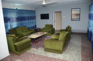 une salle d'attente avec des chaises, une table et une télévision dans l'établissement House 5 Ibara Housing, Abeokuta, à Abeokuta