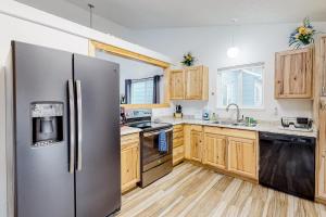 una cocina con nevera de acero inoxidable y armarios de madera en Springs Manor, en Colorado Springs