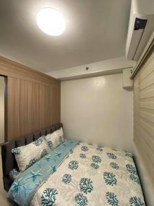 een slaapkamer met een bed met blauwe en witte lakens bij Shore Residences in Manilla