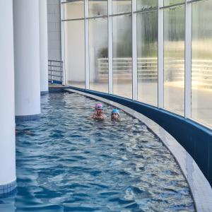 two people swimming in an indoor swimming pool at Euromarina 2 Reñaca Vista al Mar in Viña del Mar