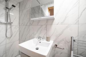 een witte badkamer met een wastafel en een douche bij Brand new 1Bed Apt - ZONE 1 - 4 Stations Nearby in Londen