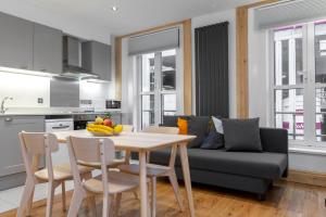 een keuken en een woonkamer met een tafel en een bank bij Brand new 1Bed Apt - ZONE 1 - 4 Stations Nearby in Londen
