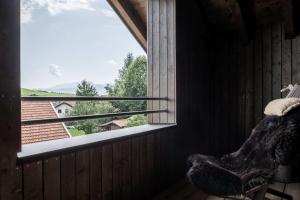 a teddy bear sitting in a room looking out a window at Chalets Lara & Louise in Rieden am Forggensee