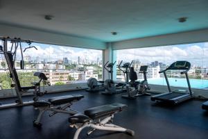 un gimnasio con máquinas de correr y una gran ventana en Lincoln Suite, en Santo Domingo