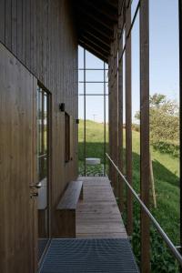 un porche de madera con un banco en un edificio en Chalets Lara & Louise en Rieden