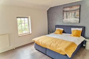 sypialnia z niebieskim łóżkiem z żółtą pościelą w obiekcie Fermette du volcan w mieście Namur