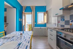 シラクーサにあるAsteria by Dimore in Sicilyの青い壁のキッチン(テーブル付)