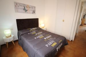 ein Schlafzimmer mit einem Bett mit einer schwarzen Bettdecke in der Unterkunft Apart-rent Apartamento Gran reserva 0068 in Empuriabrava