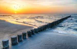 a pier stretches out into the ocean at sunset at Seeblick Roter Sand in Wangerooge